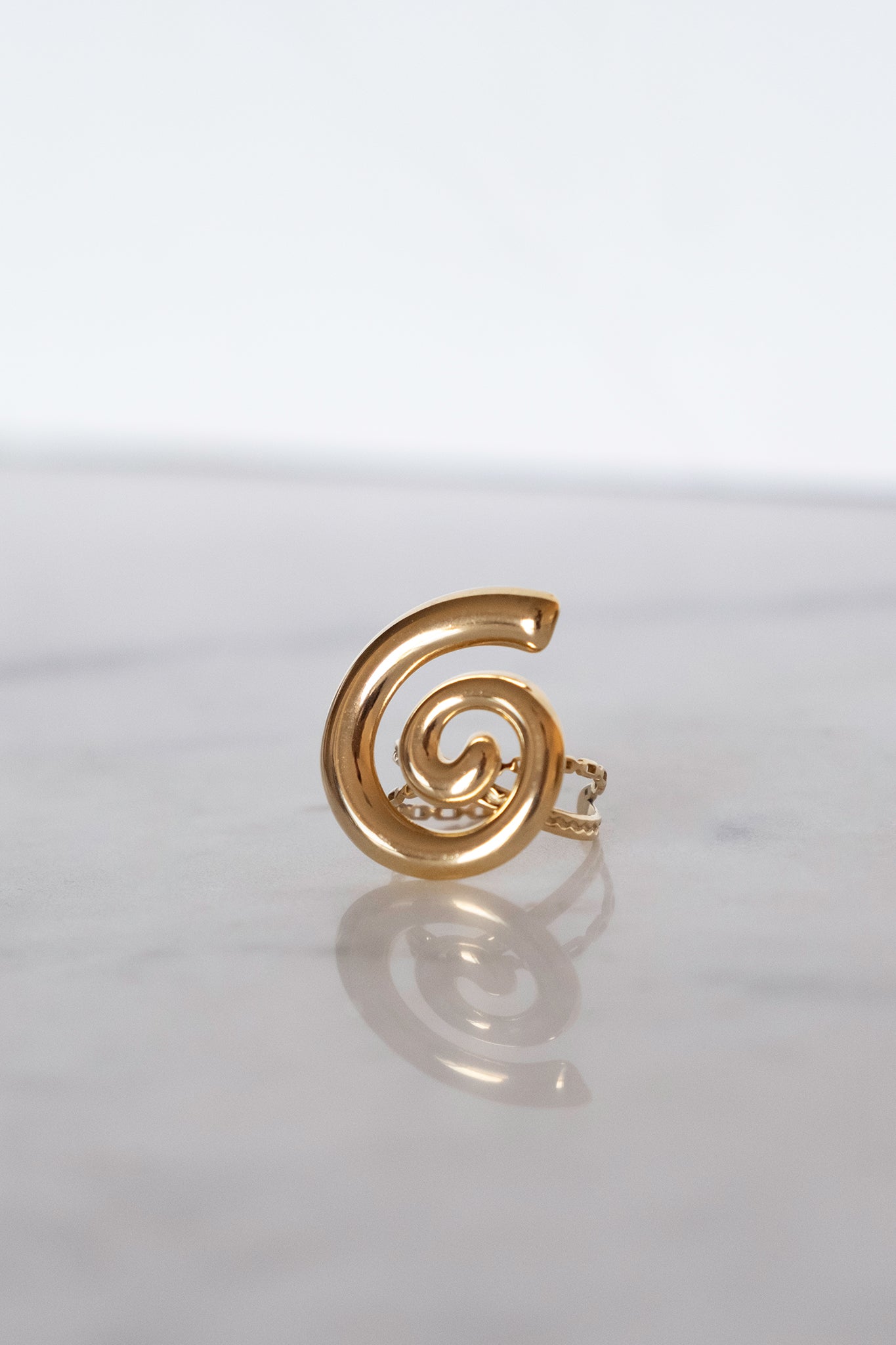 Golden swirl adjustable ring from Larrea Cove's jewelry collection, a perfect boho accessory for effortless coastal style.
