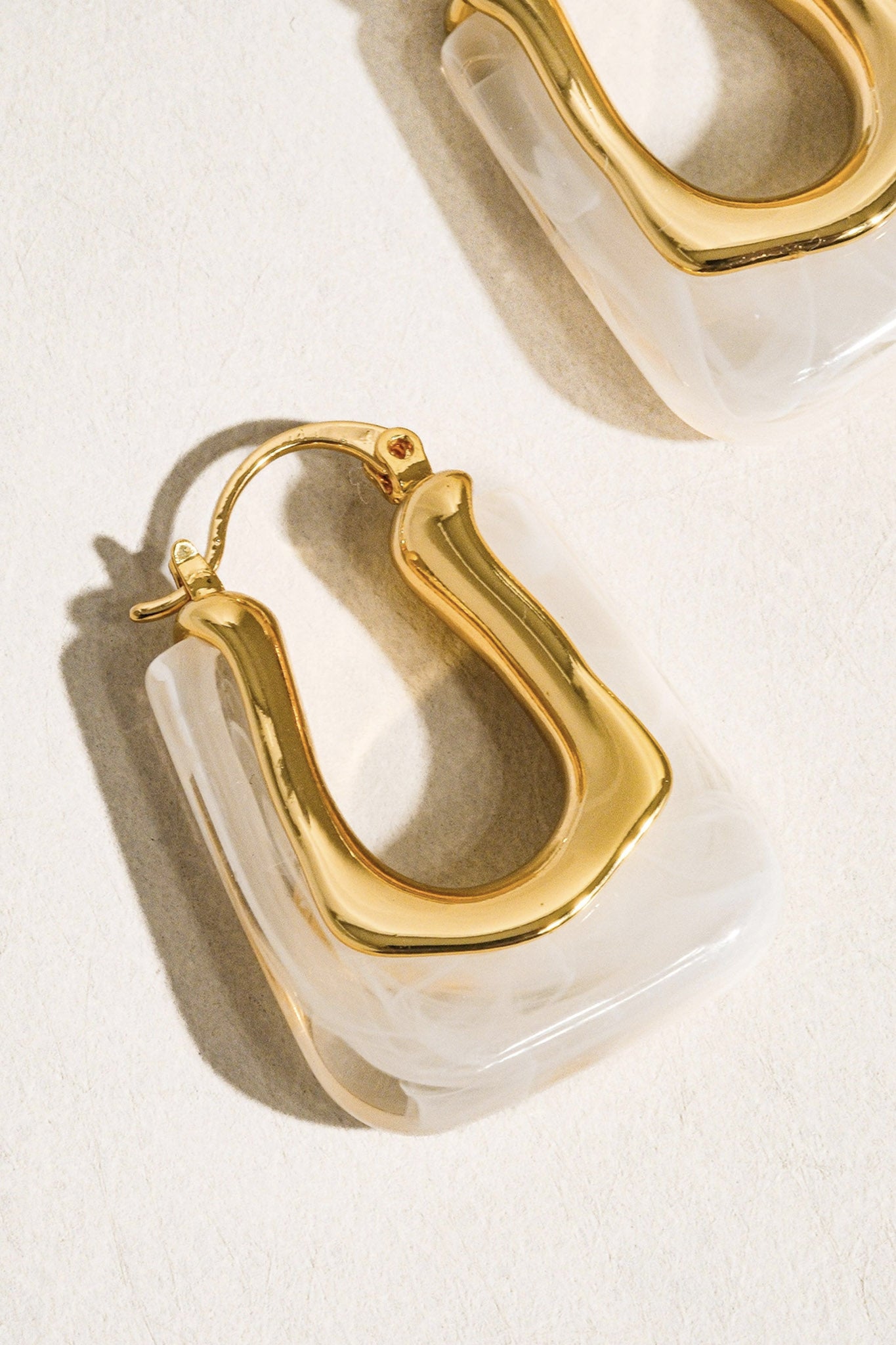 Embrace coastal chic with Larrea Cove's U-shaped boho hoop earring in white, a perfect addition to your accessory collection.