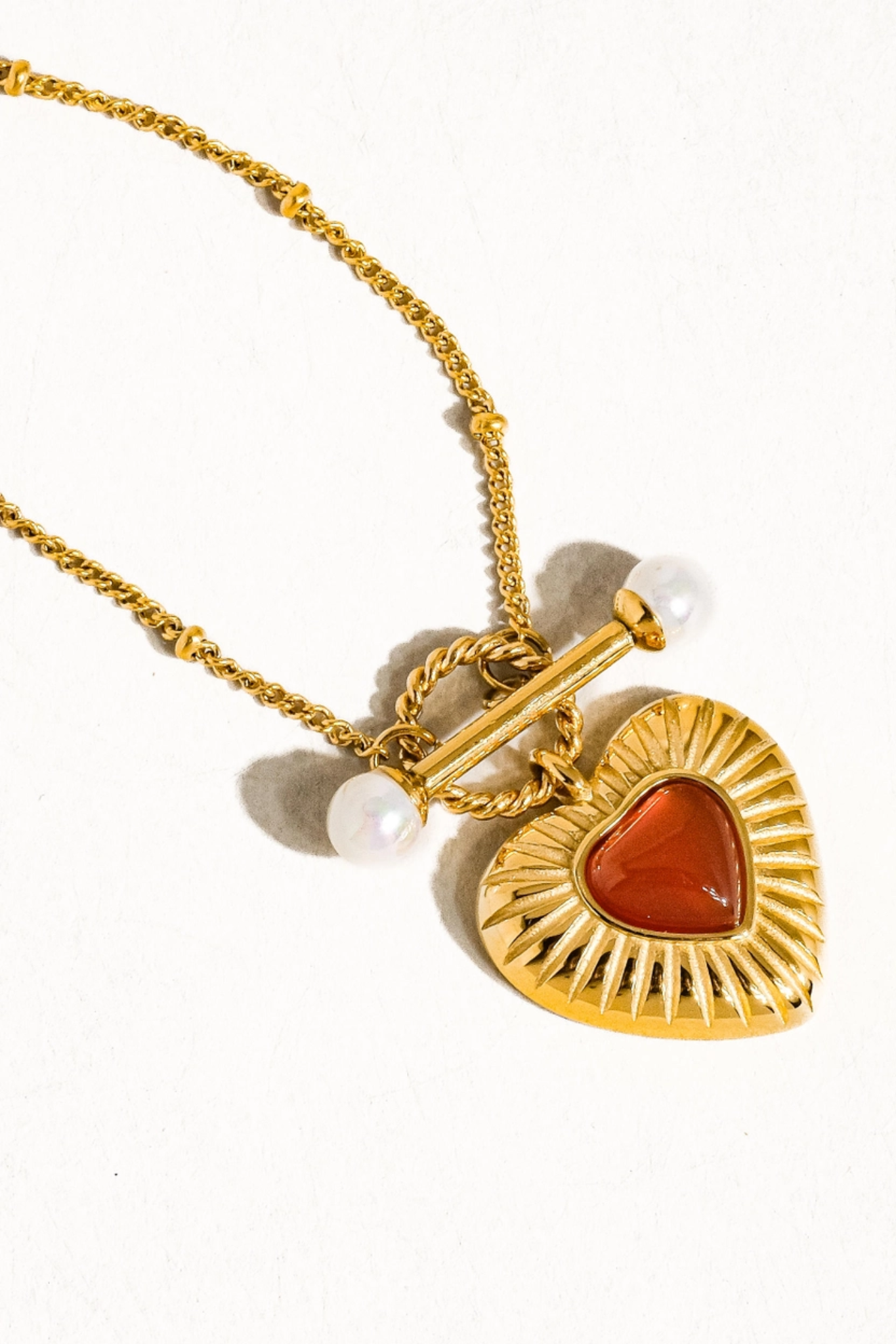 A delicate 18K gold-plated vintage heart chain necklace featuring intricate heart-shaped links. The necklace showcases a refined, non-tarnish finish, ideal for elegant styling. It is displayed against a neutral background, highlighting its shiny surface and intricate design, making it a perfect accessory for various outfits.