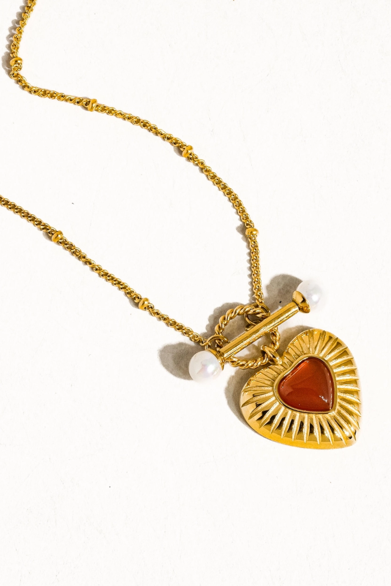 A delicate 18K gold-plated vintage heart chain necklace featuring intricate heart-shaped links. The necklace showcases a refined, non-tarnish finish, ideal for elegant styling. It is displayed against a neutral background, highlighting its shiny surface and intricate design, making it a perfect accessory for various outfits.