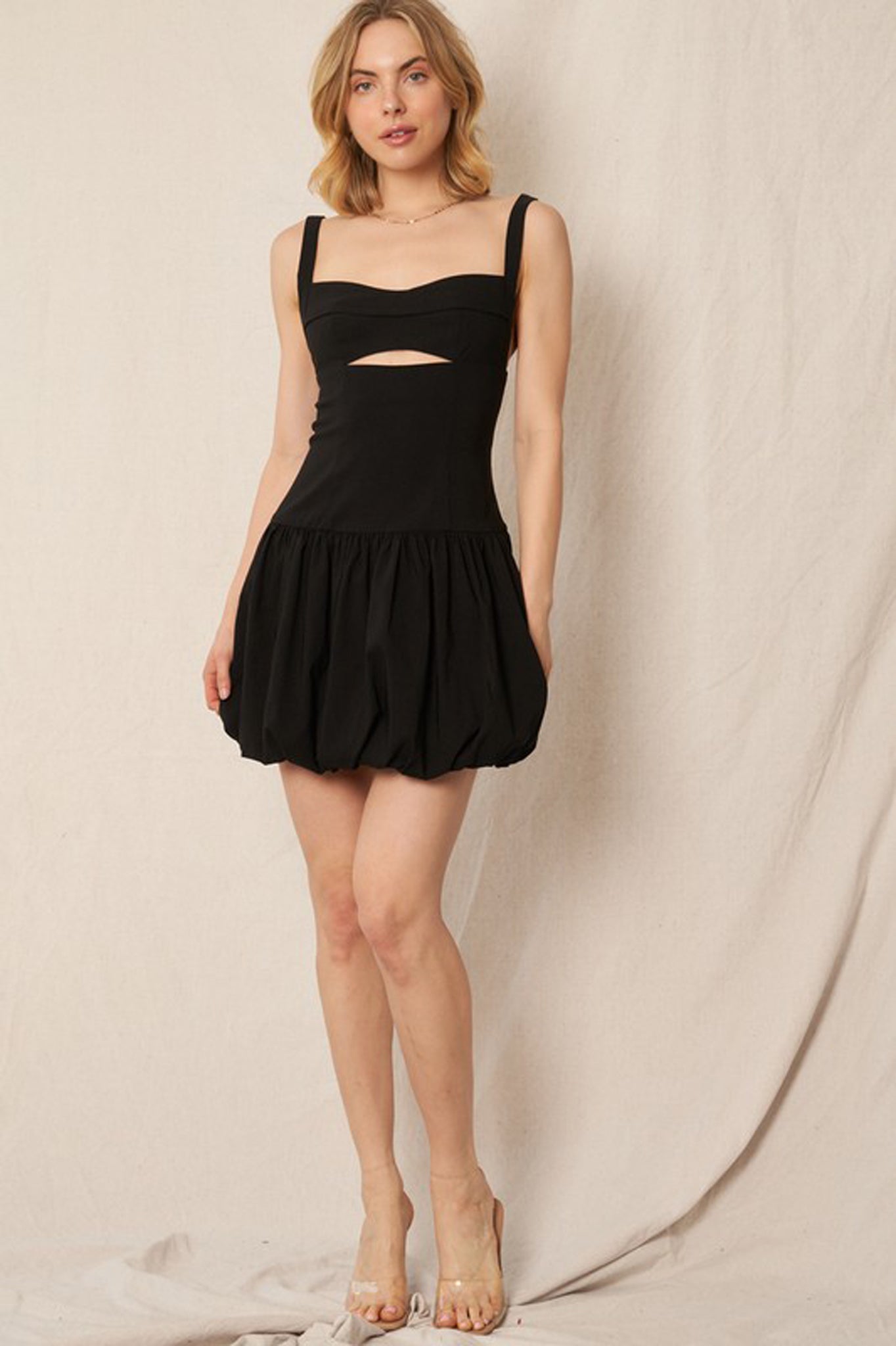 A fashionable balloon hem mini dress by Larrea Cove, featuring a stylish design suitable for Fall 2024. The dress is paired with chic sunglasses, highlighting its trendy appeal. Ideal for a modern wardrobe, this new product is categorized under Dresses by En Creme.