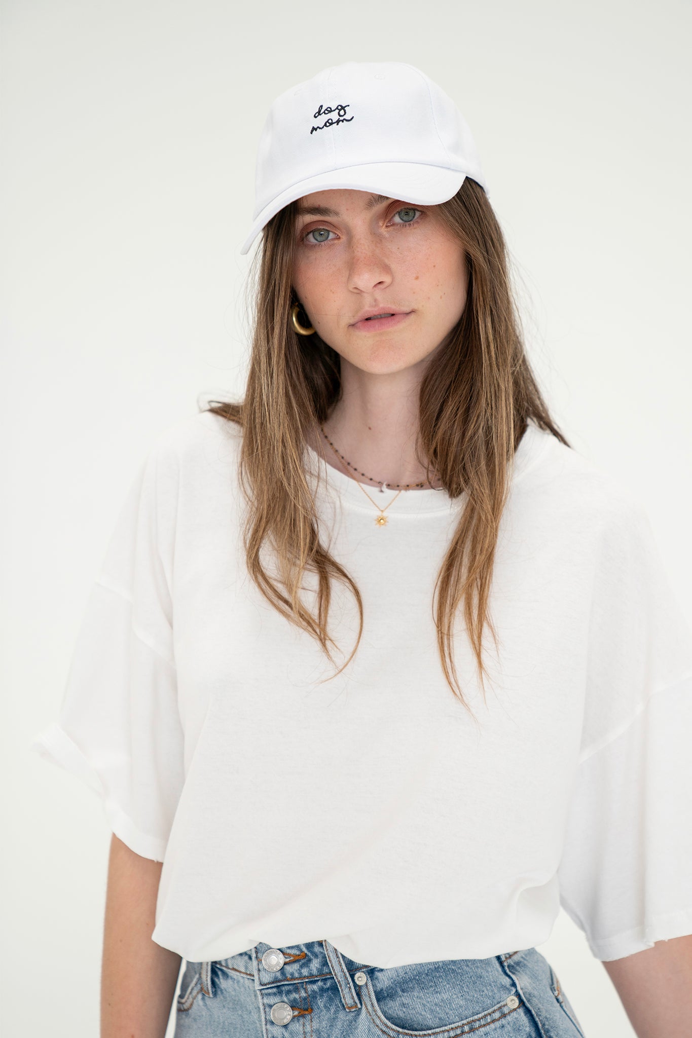 View 1 of Dog Mom Hat in White, a Hats from Larrea Cove. Detail: This classic dad hat features the slogan "dog mom" embroi...