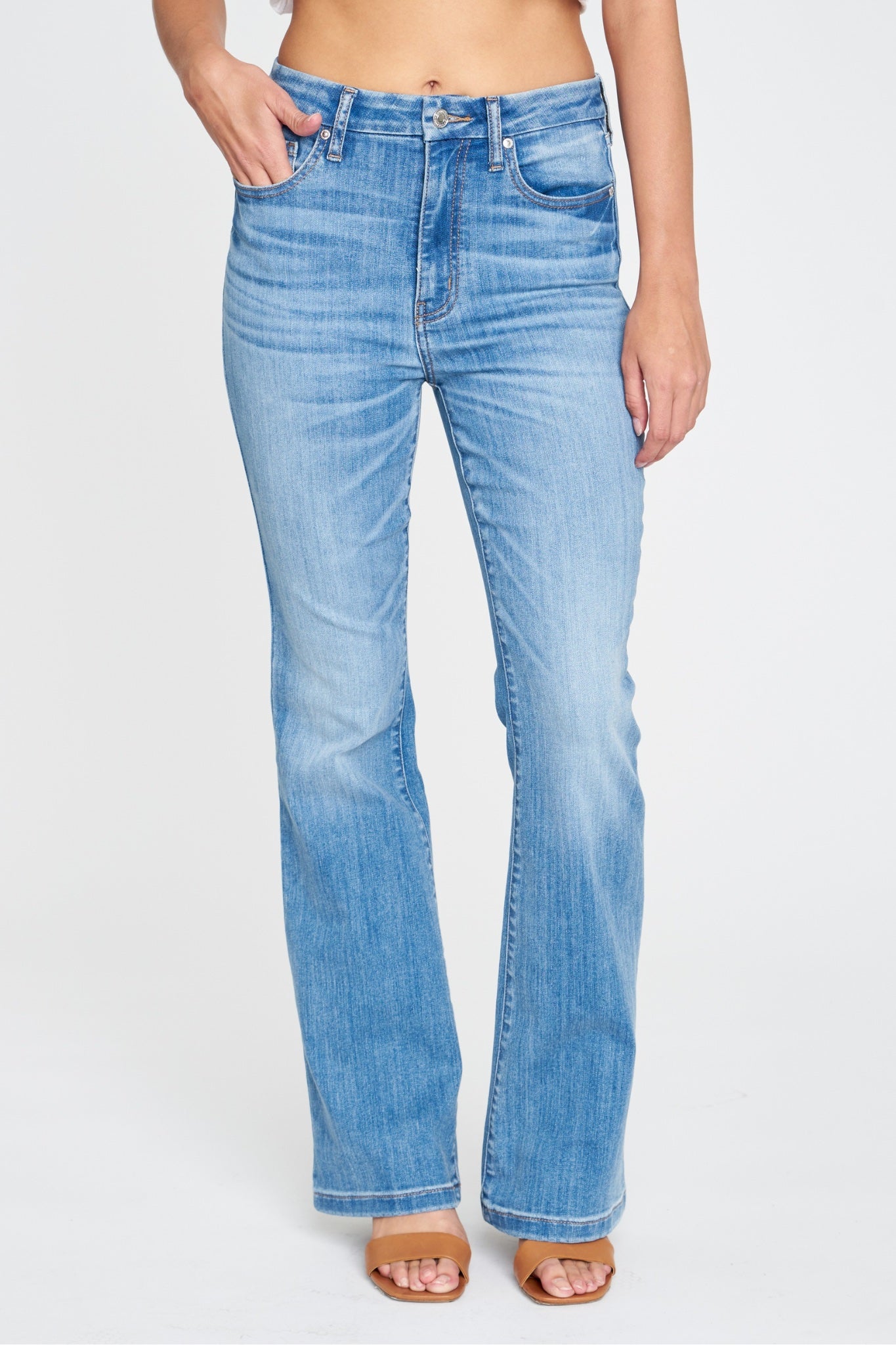 Eunina Aliyah Super High Rise Flare jeans in Verbena color, featuring a stylish flared leg design. The jeans are displayed on a neutral background, emphasizing their vibrant hue. Accompanied by a pair of sunglasses, highlighting the casual and trendy look. Tags include jeans, coupon, Eunina, new for May 2024.