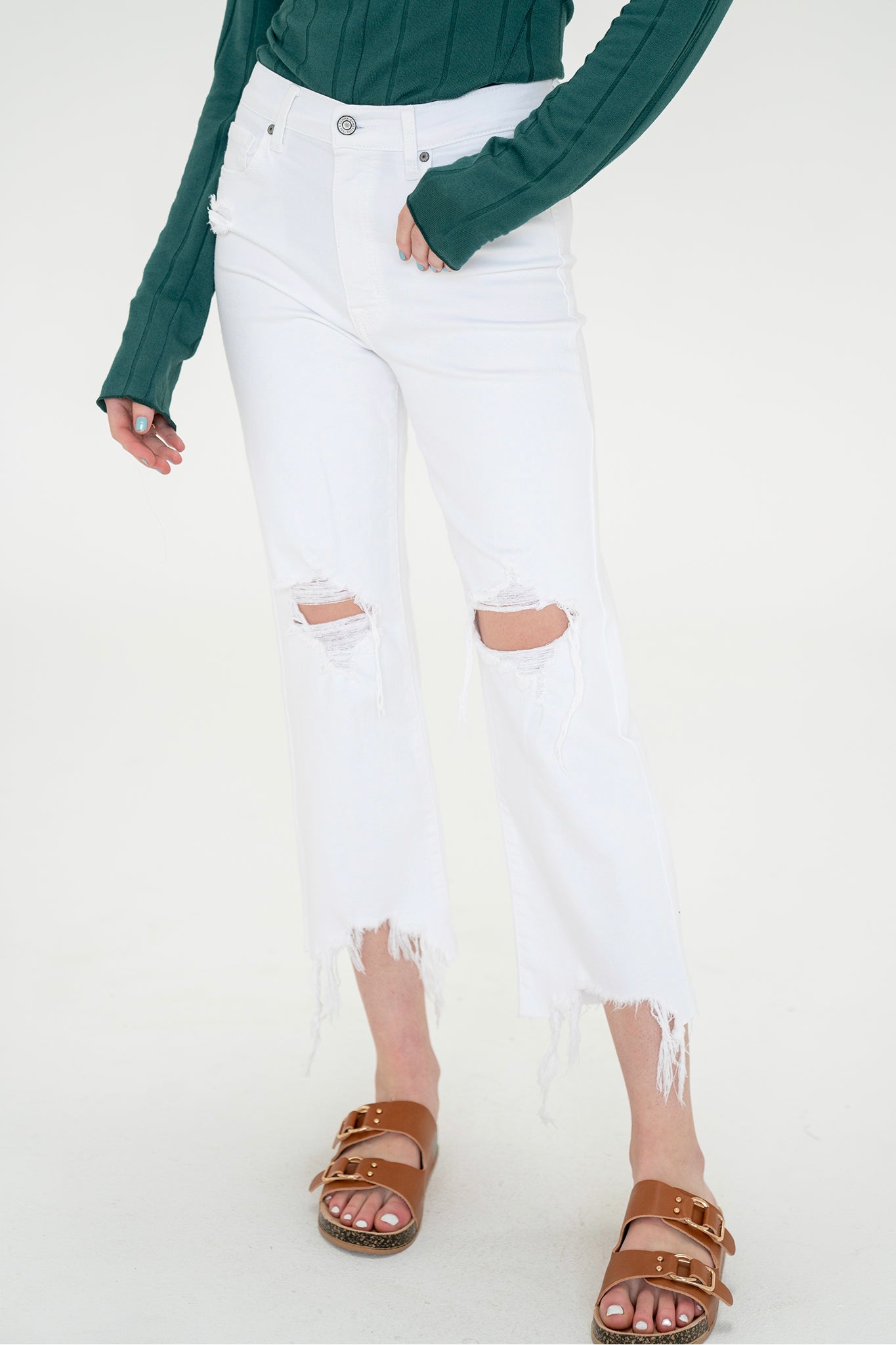 A pair of Eunina Dawn Wide Leg Jeans in Datura, featuring a clean white wash with a raw shredded hem and distressed knees. The jeans have a super high rise, five-pocket design, belt loops, and a hidden zip fly with button closure. The model, standing tall at 5'9.5", showcases the jeans styled with sunglasses. The fabric content is 99% cotton and 1% elastane, and the model is wearing a size 5.
