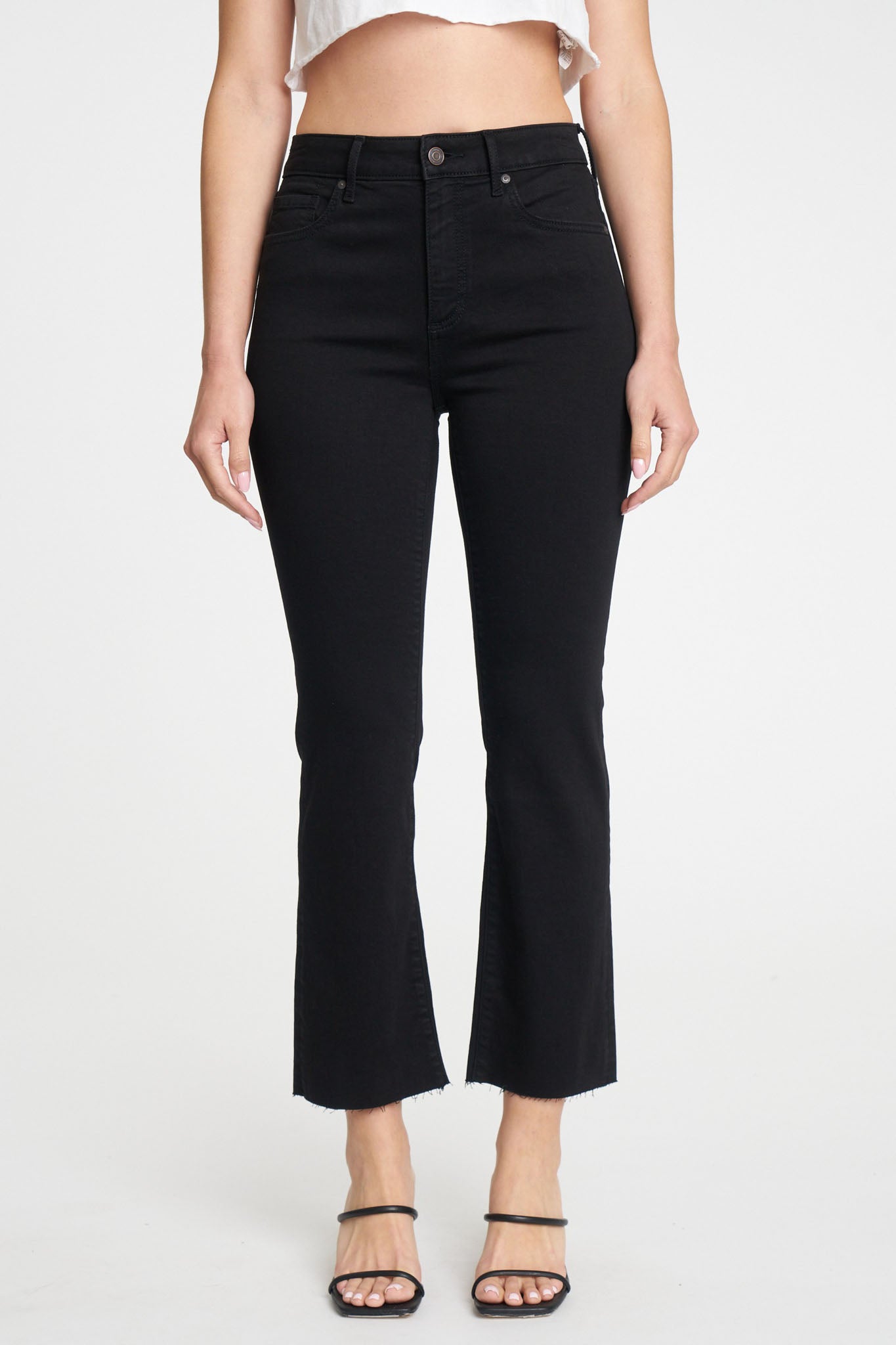 Eunina Emery high rise cropped boot jeans in Desert Night, featuring a classic black wash, five-pocket design, and belt loops. The model is wearing the jeans with a slim fit through the hip and thigh, showcasing a slight flare above the ankle. The jeans are styled with sunglasses for a trendy look.