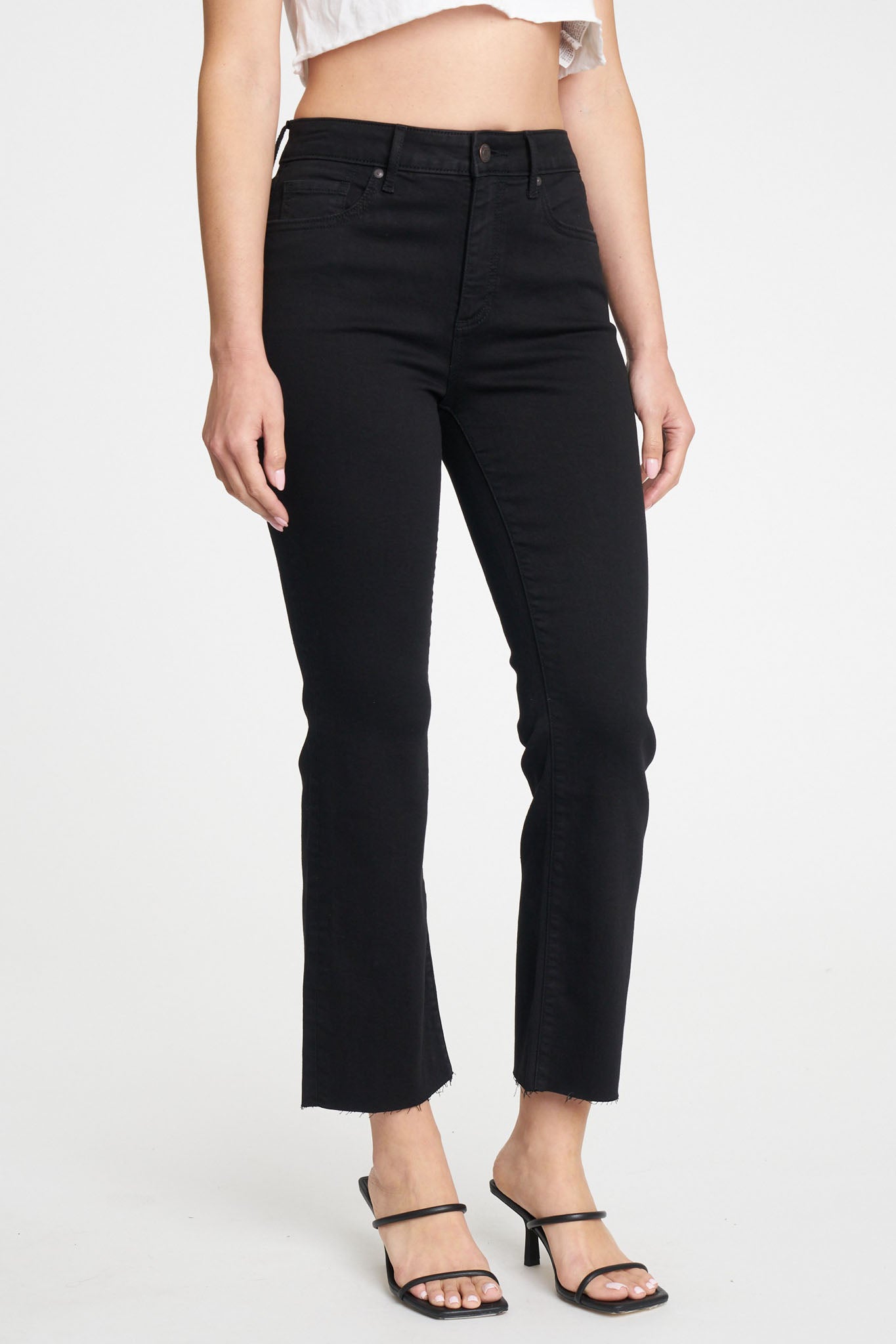 The image features Eunina Emery Cropped Boot Jeans in a deep blue shade called Desert Night. The jeans are styled with a slight bootcut at the hem and a cropped length, ideal for a trendy fall look. Accompanying the jeans are stylish sunglasses, adding a fashionable touch to the outfit. The overall aesthetic conveys a modern and chic vibe suitable for casual wear.