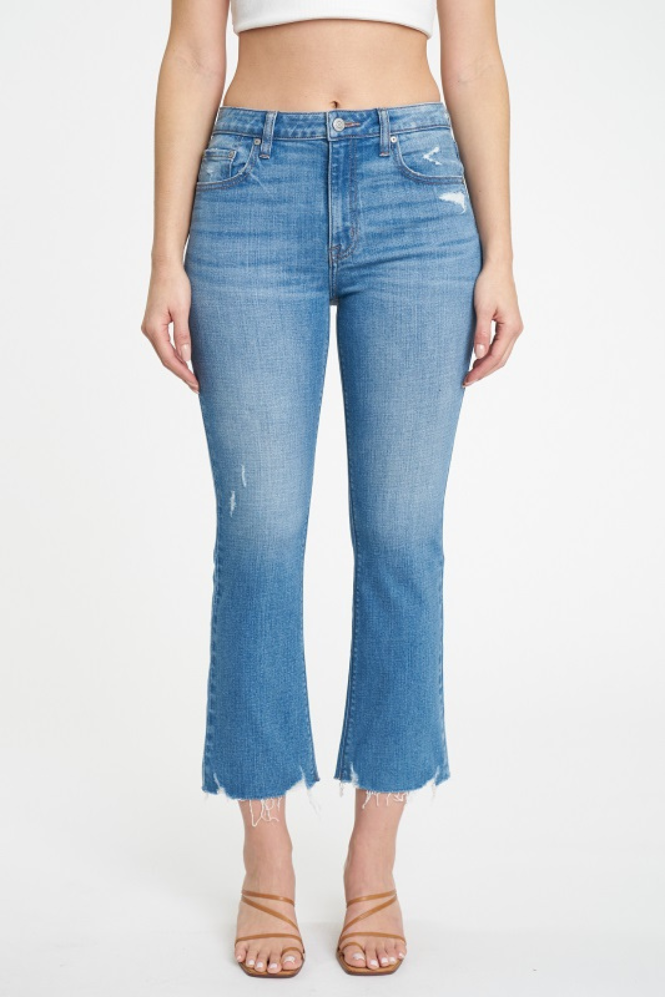 Alt text: A pair of Eunina Emery Cropped Boot Jeans in a medium wash, featuring a high rise, five-pocket design, and a slight flare above the ankle. The jeans are displayed on a neutral background, emphasizing their classic style. Accompanying the jeans are sunglasses, enhancing the casual, stylish look.