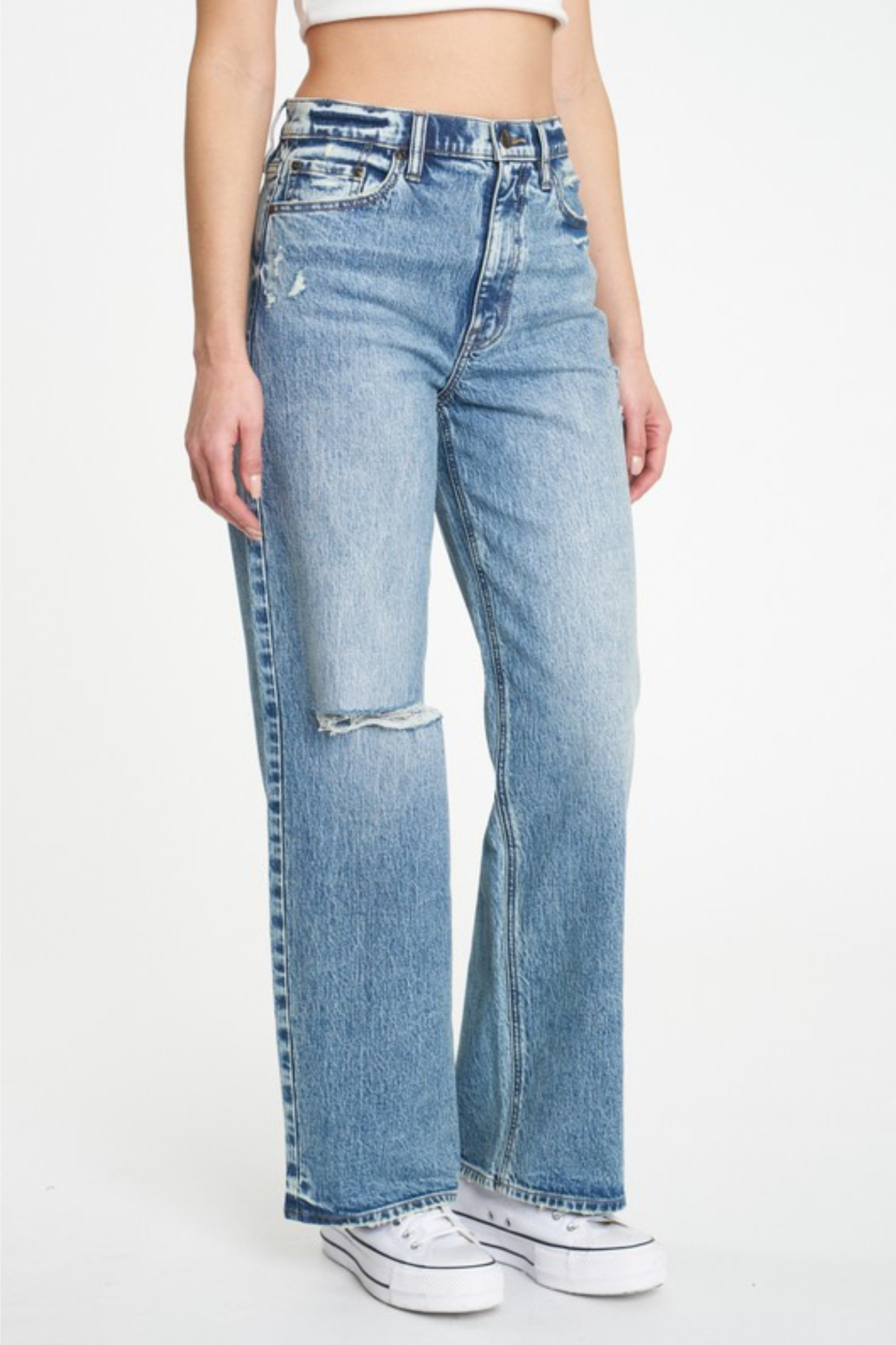 Alt text: A model wearing Eunina Ryder Baggy Jeans in Heisler Park, styled with sunglasses. The jeans feature a relaxed fit and distressed detailing, showcasing a casual, trendy look.