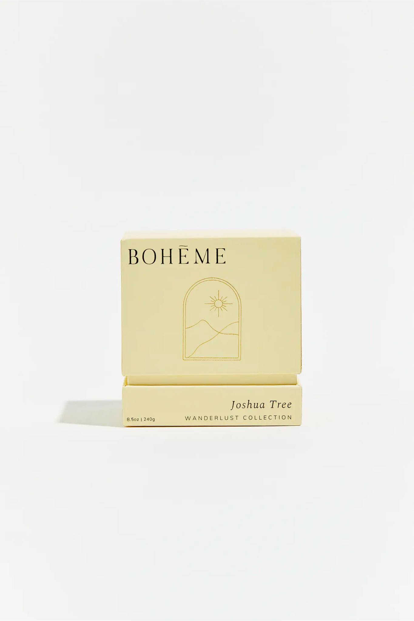 Image of the Boheme Joshua Tree Candle, featuring a stylish jar with a desert-themed design. The candle is 8.5 oz, made from all-natural wax, and has a clean burn with cotton wicks. It offers a fragrance profile of bergamot and agave top notes, tuberose and cactus blossom middle notes, and base notes of desert sands, amber, patchouli, and incense. The candle is presented in a chic setting, emphasizing its aesthetic appeal for home décor.