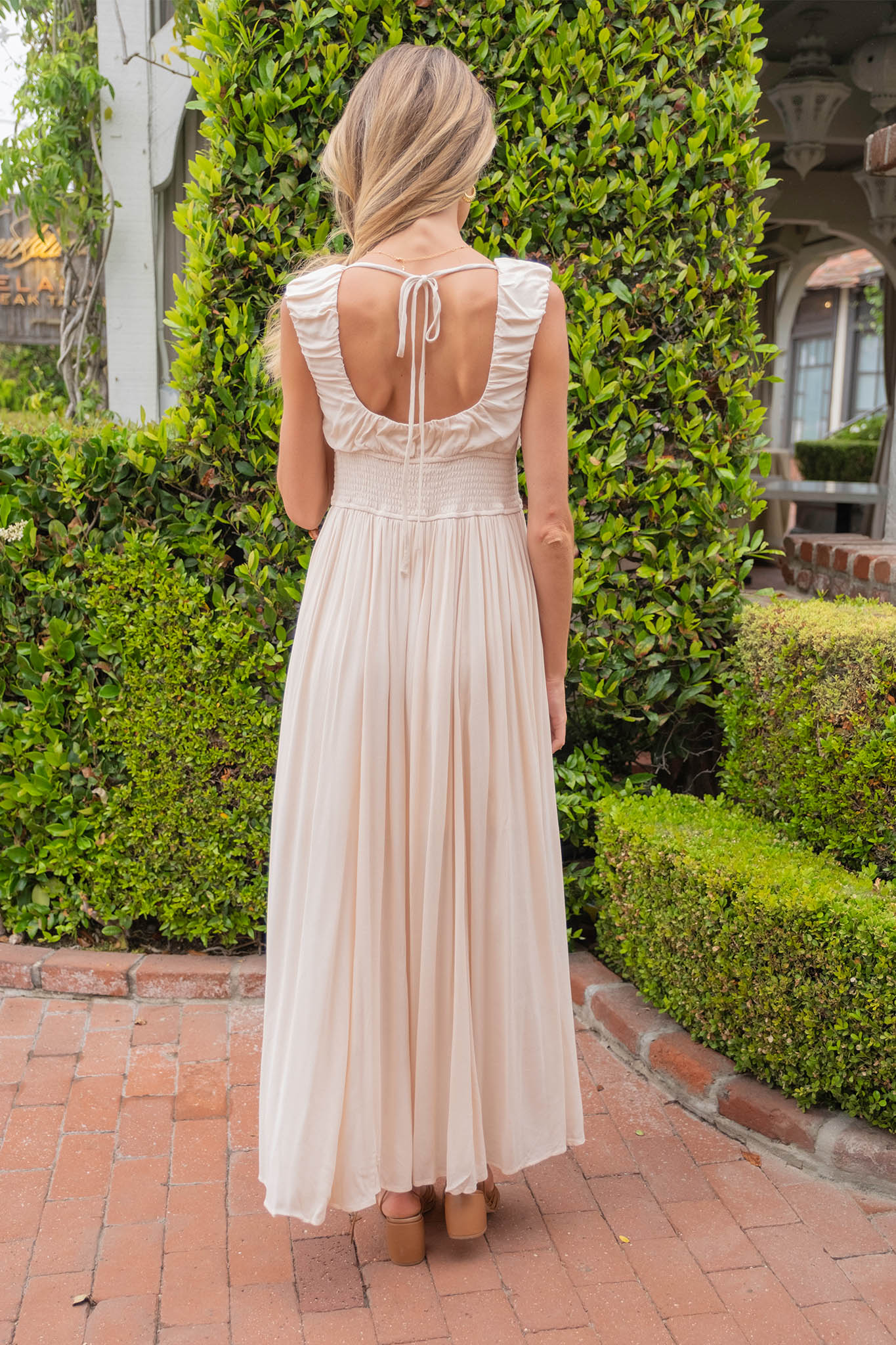 A stylish Kasey Maxi Dress by Larrea Cove, featuring a vibrant Poppi Seed pattern, designed for Summer 2024. The dress is showcased on a mannequin or hanger, complemented by trendy sunglasses. The image highlights the flowing silhouette and fabric texture, perfect for warm-weather occasions.