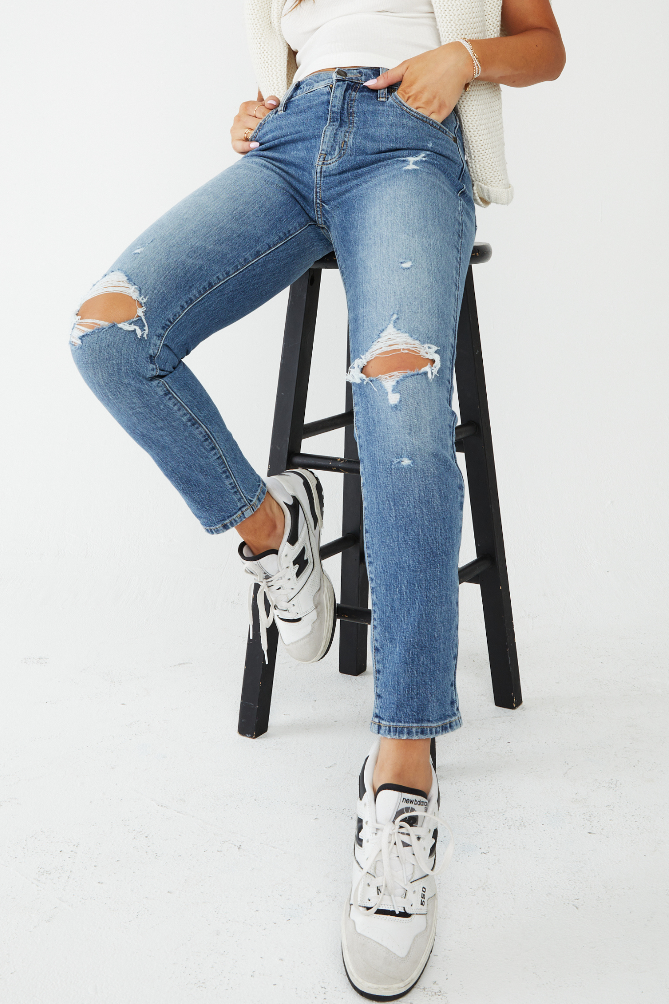 A pair of Eunina Tobi Mom Jeans in Whipple, featuring a relaxed fit and classic five-pocket styling. The jeans are styled with a pair of trendy sunglasses. The product is tagged as new and restocked for July 2024, categorized under jeans and pants in the apparel and accessories section.