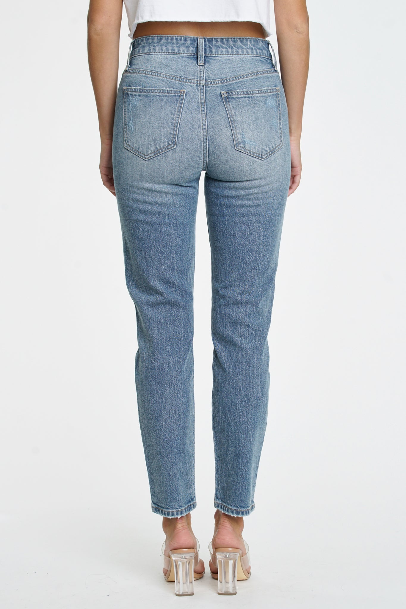 A pair of Eunina Tobi Mom Jeans in Whipple, featuring a relaxed fit and a light wash, displayed against a simple background. Accompanying the jeans are stylish sunglasses, enhancing the casual look. The product is part of Eunina's 2024 collection and is available for restock.