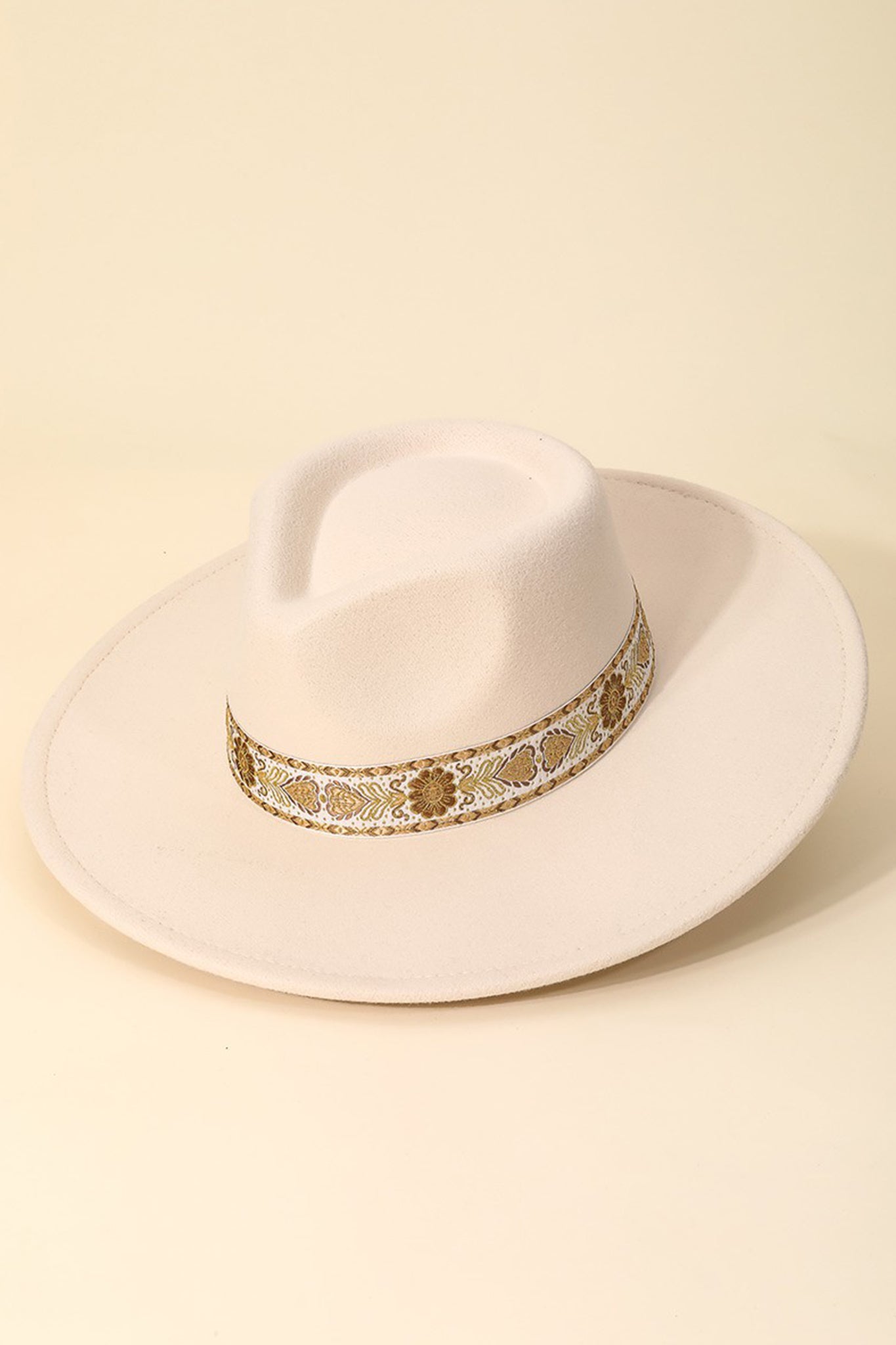 A stylish ivory hat featuring a soloman pattern stripe design by Larrea Cove. The hat is paired with sunglasses, showcasing a chic, fashionable look suitable for sunny days.