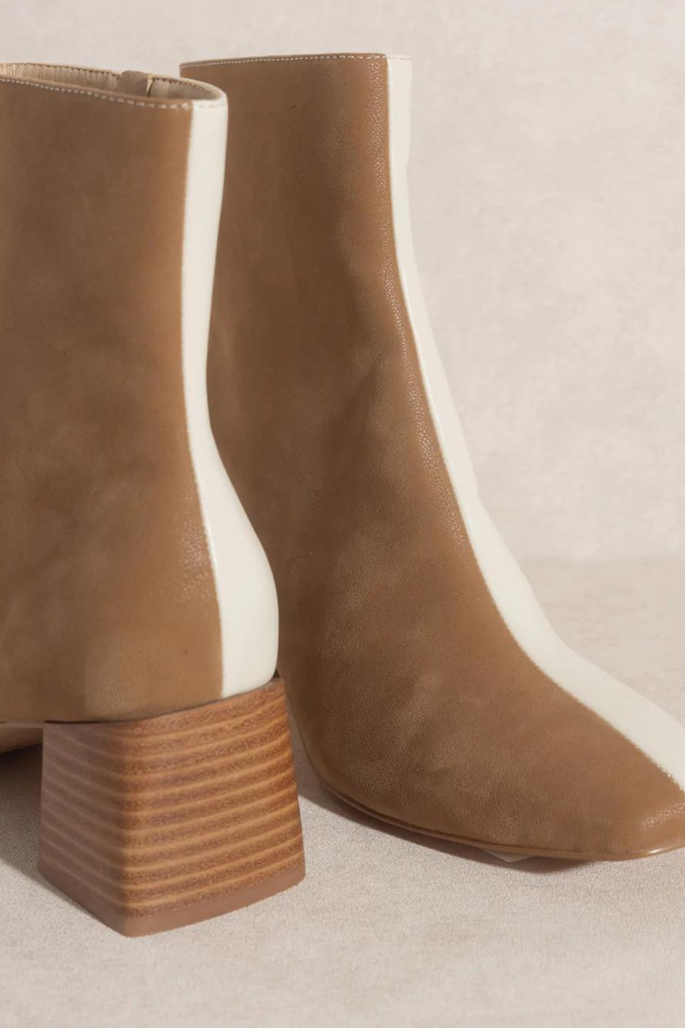Oasis Society Georgia Dual Chroma Bootie, a stylish ankle boot featuring a dual-tone design, showcased on a neutral background. Accompanied by a pair of trendy sunglasses. Product category: Shoes, marked as a new item from September 2022 and currently on sale.