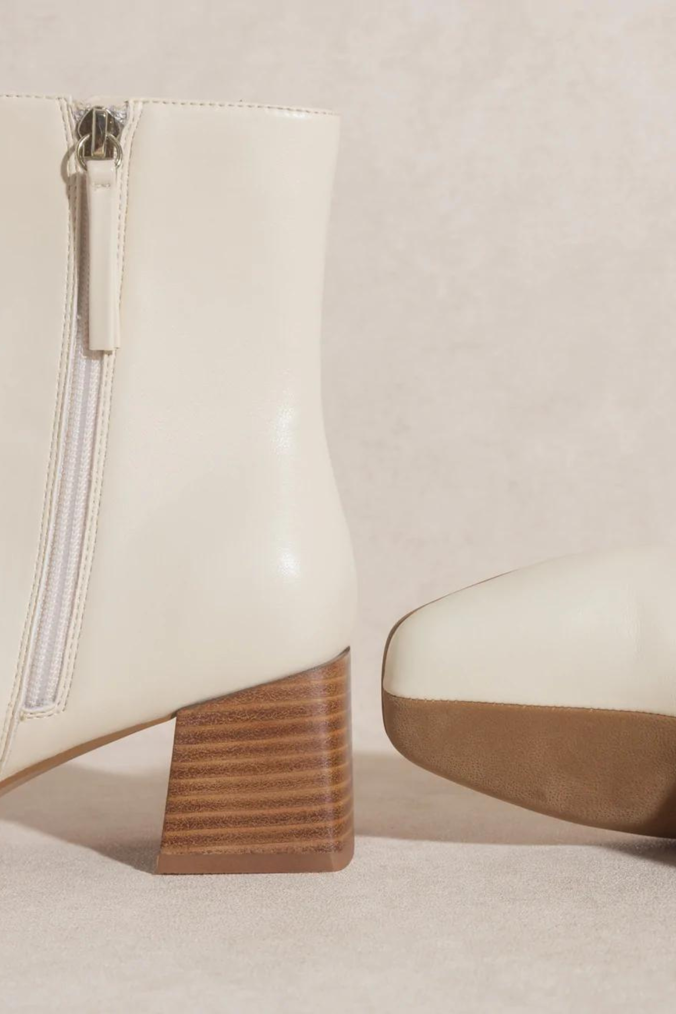 Oasis Society Georgia Dual Chroma Bootie, a stylish shoe featuring a unique dual-tone design, displayed against a neutral background. The bootie showcases a modern silhouette, perfect for fashionable outfits. Accompanied by sunglasses, emphasizing a trendy look. Tagged as new product from September 2022 and currently on sale.