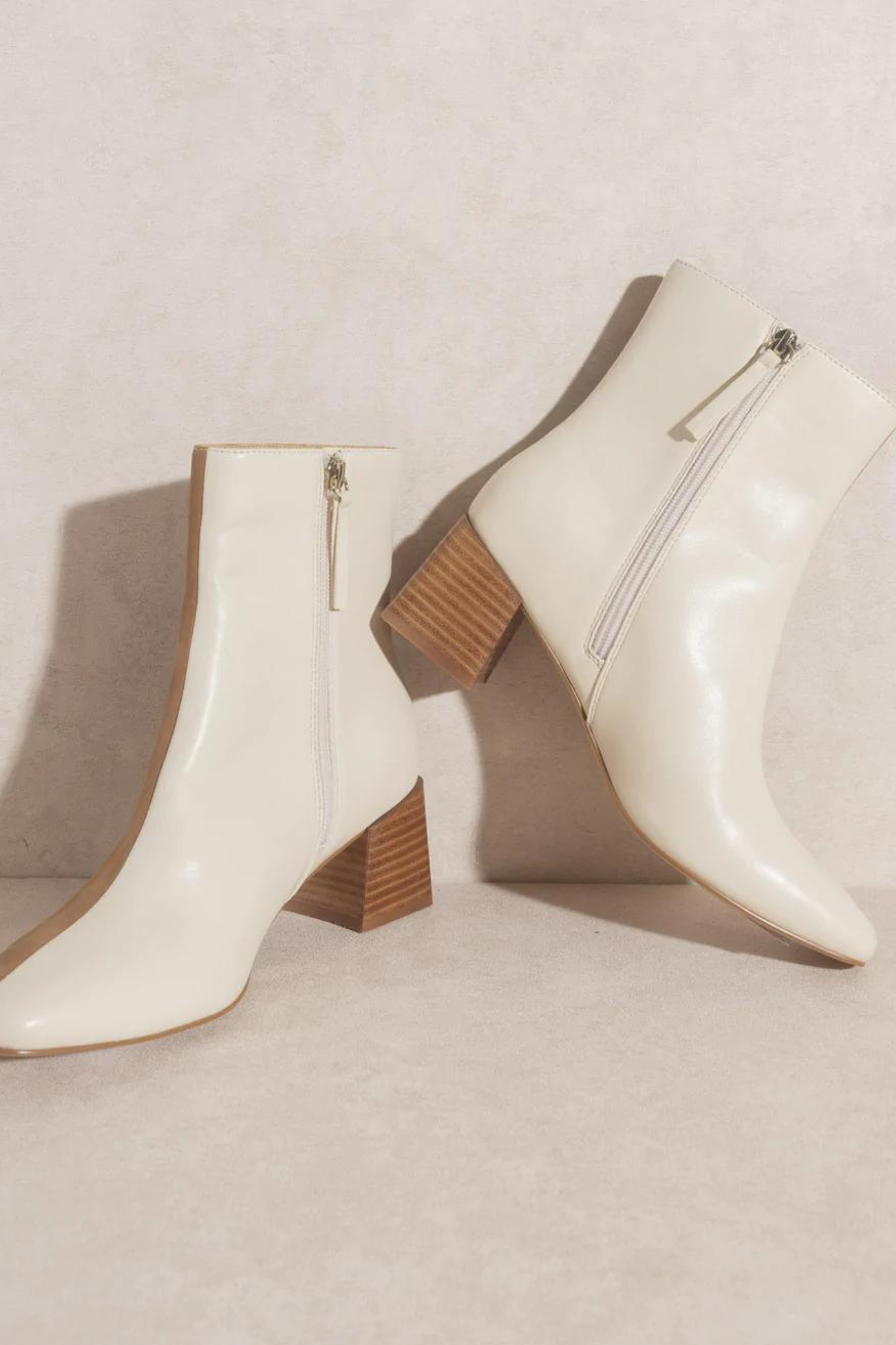 Oasis Society Georgia Dual Chroma Bootie in a stylish design, featuring a combination of colors and textures. The bootie is showcased alongside sunglasses, emphasizing a fashionable look. Ideal for trendy footwear enthusiasts.