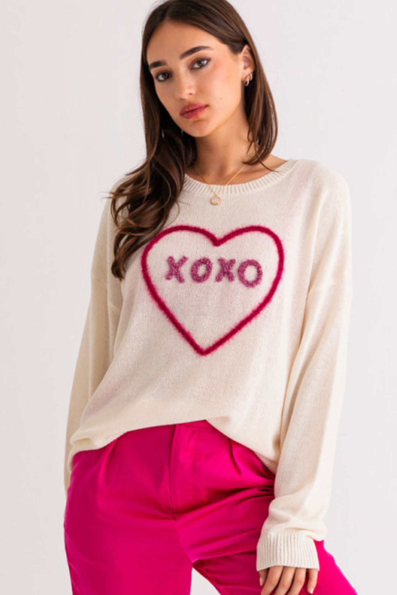 A stylish XOXO sweater top by Larrea Cove, featuring a cozy design suitable for casual wear. The image showcases the sweater in a flattering fit, perfect for layering. Accompanying the sweater are trendy sunglasses, enhancing the fashionable look. The product belongs to the Sweaters category and is part of a seasonal sale.