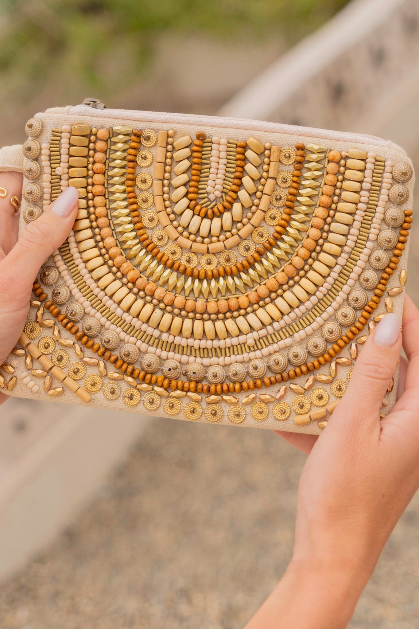 Allegra Beaded Wristlet in Gold by ANTIK KRAFT, featuring a compact design adorned with colorful beads, lined interior, and measuring 8 inches by 6 inches. Ideal for carrying small essentials, showcasing a boho beachy chic style.