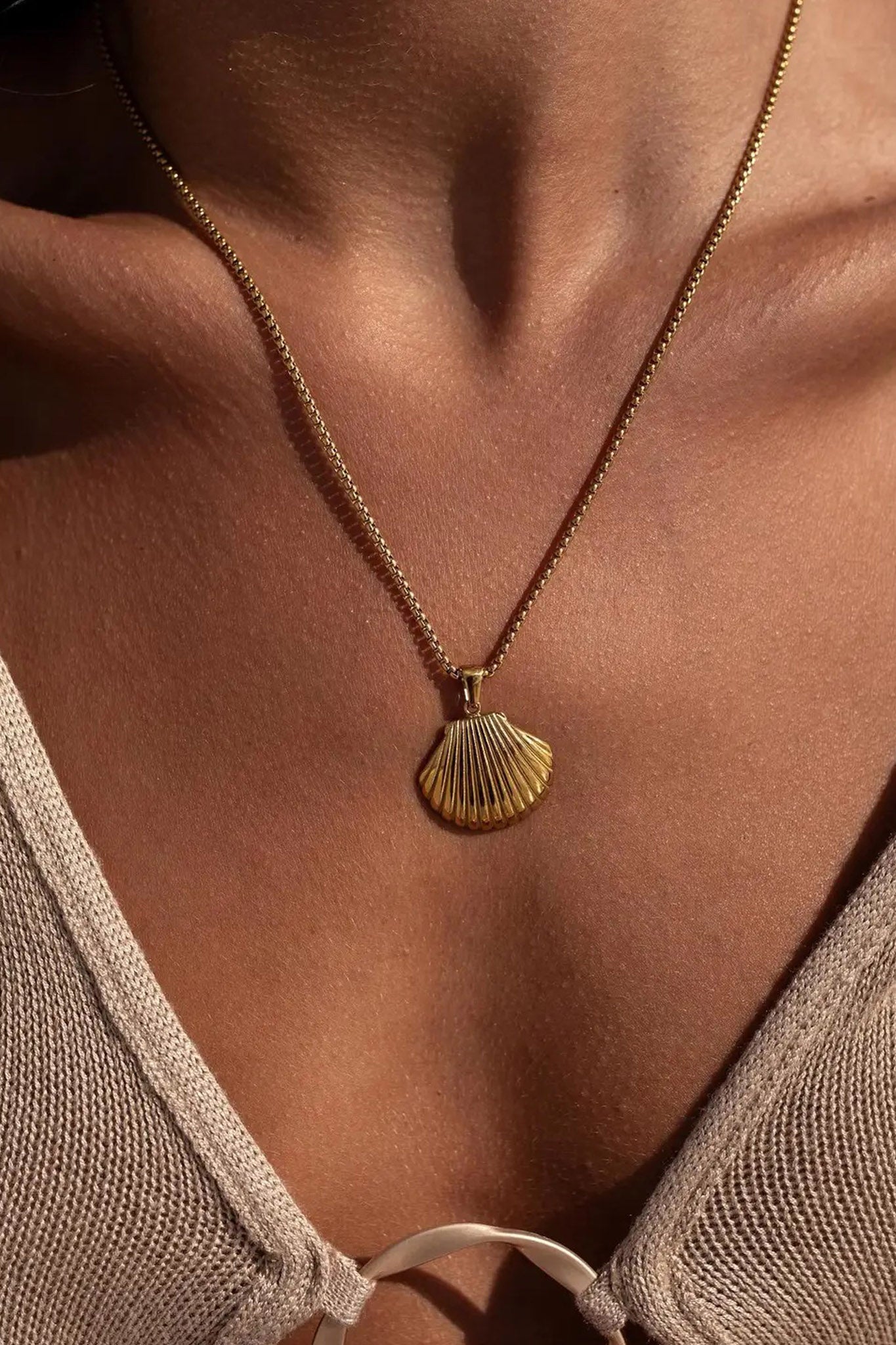 Cress Seashell Necklace featuring an 18K gold-plated design, made from stainless steel, nickel and lead-free, and hypoallergenic. The necklace has a lobster clasp, a 16-inch chain with a 2-inch extender, and is water-resistant.