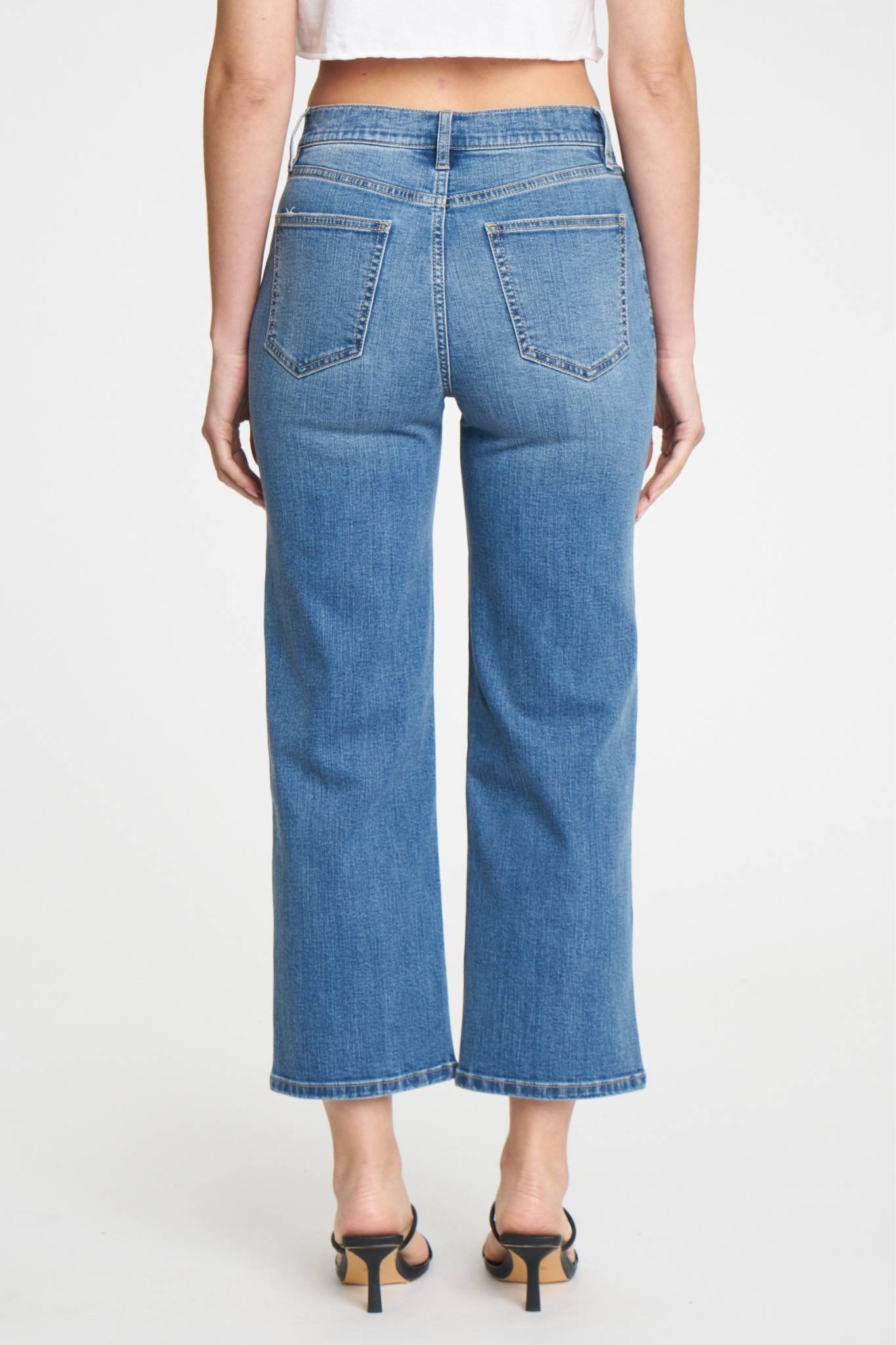 A pair of Eunina Dawn Wide Leg Jeans in Aliso, featuring a light blue wash and a relaxed fit. The jeans have a high waist and wide leg design, suitable for casual wear. Accompanying the jeans are stylish sunglasses, highlighting a trendy summer look. The image is tagged with relevant product and vendor information.