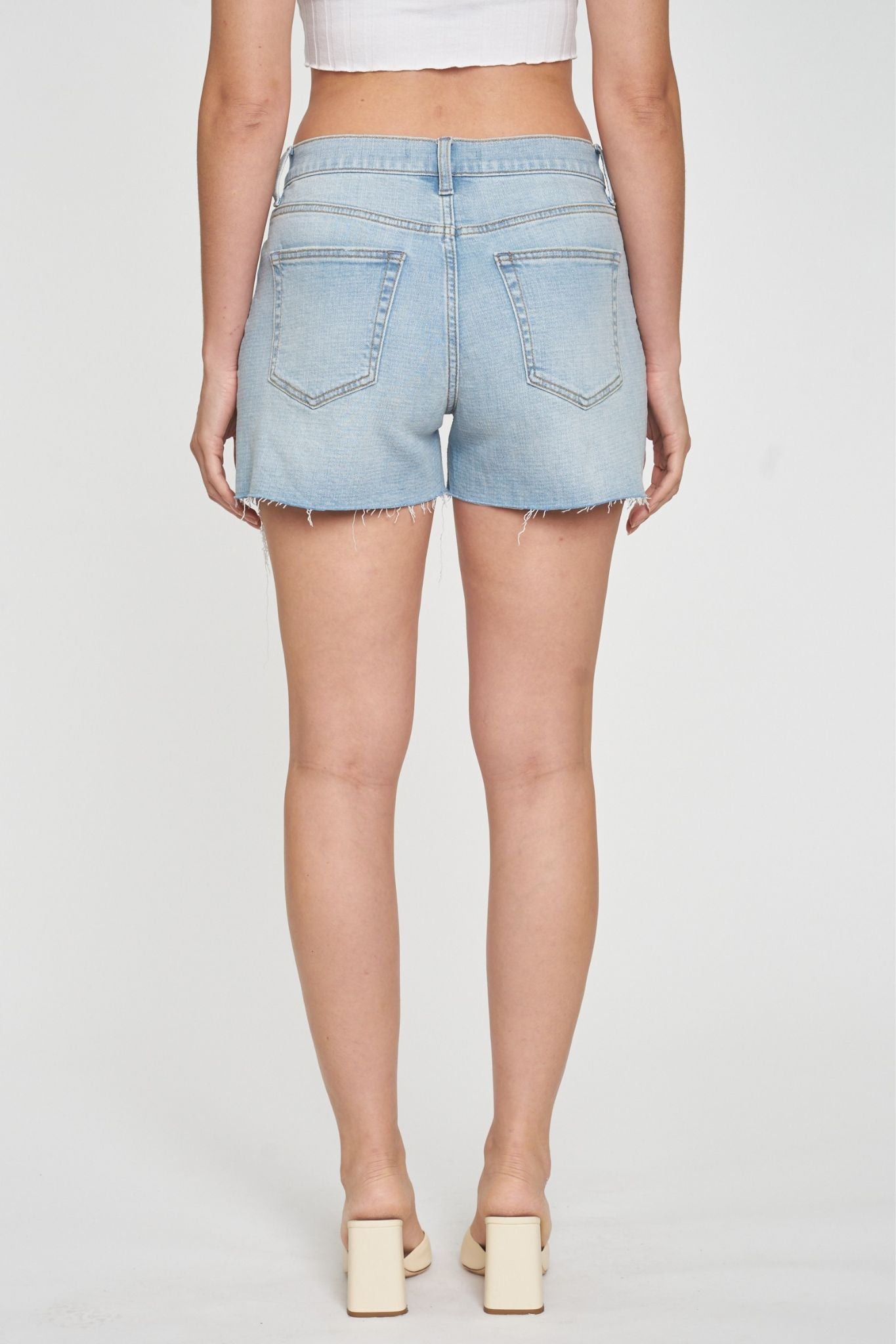 A pair of Eunina Zack Easy Shorts in Opuntia, featuring a light denim fabric with a relaxed fit. The shorts have a mid-rise waist and rolled hems, designed for comfort and style. Accompanying the shorts are a pair of stylish sunglasses. The image is tagged with various details indicating it's a new product for June 2024, available for sale.