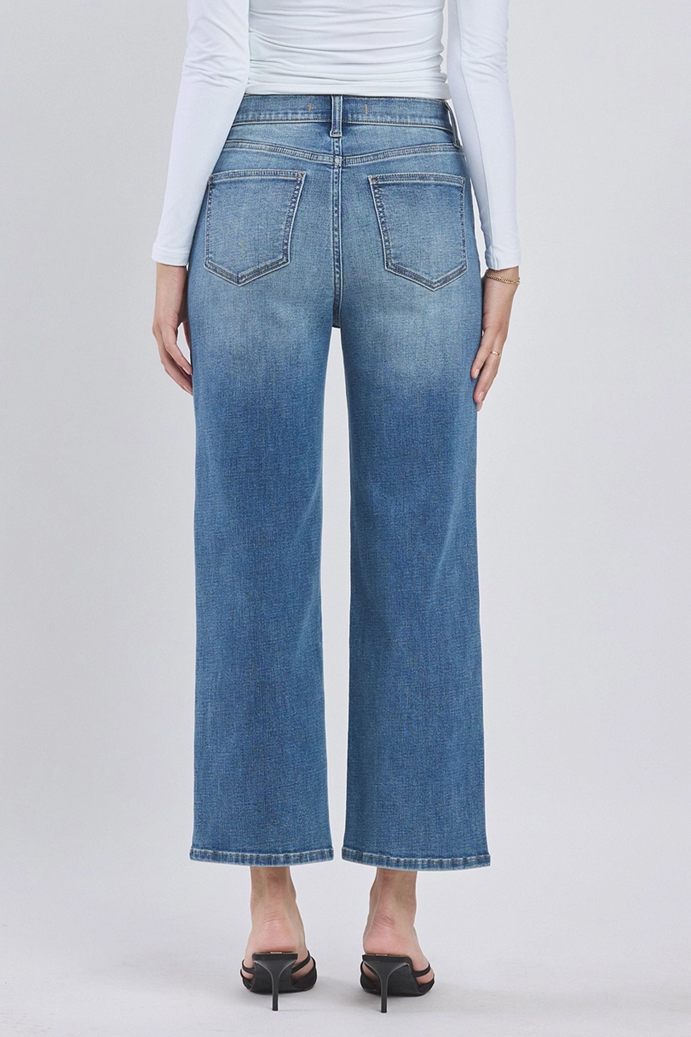 A pair of Eunina Dawn Wide Leg Jeans in Aliso, featuring a light blue denim wash with a high waist and wide leg silhouette. The jeans are styled with a pair of sunglasses placed nearby. The image highlights the jeans' relaxed fit and contemporary design, suitable for casual wear.
