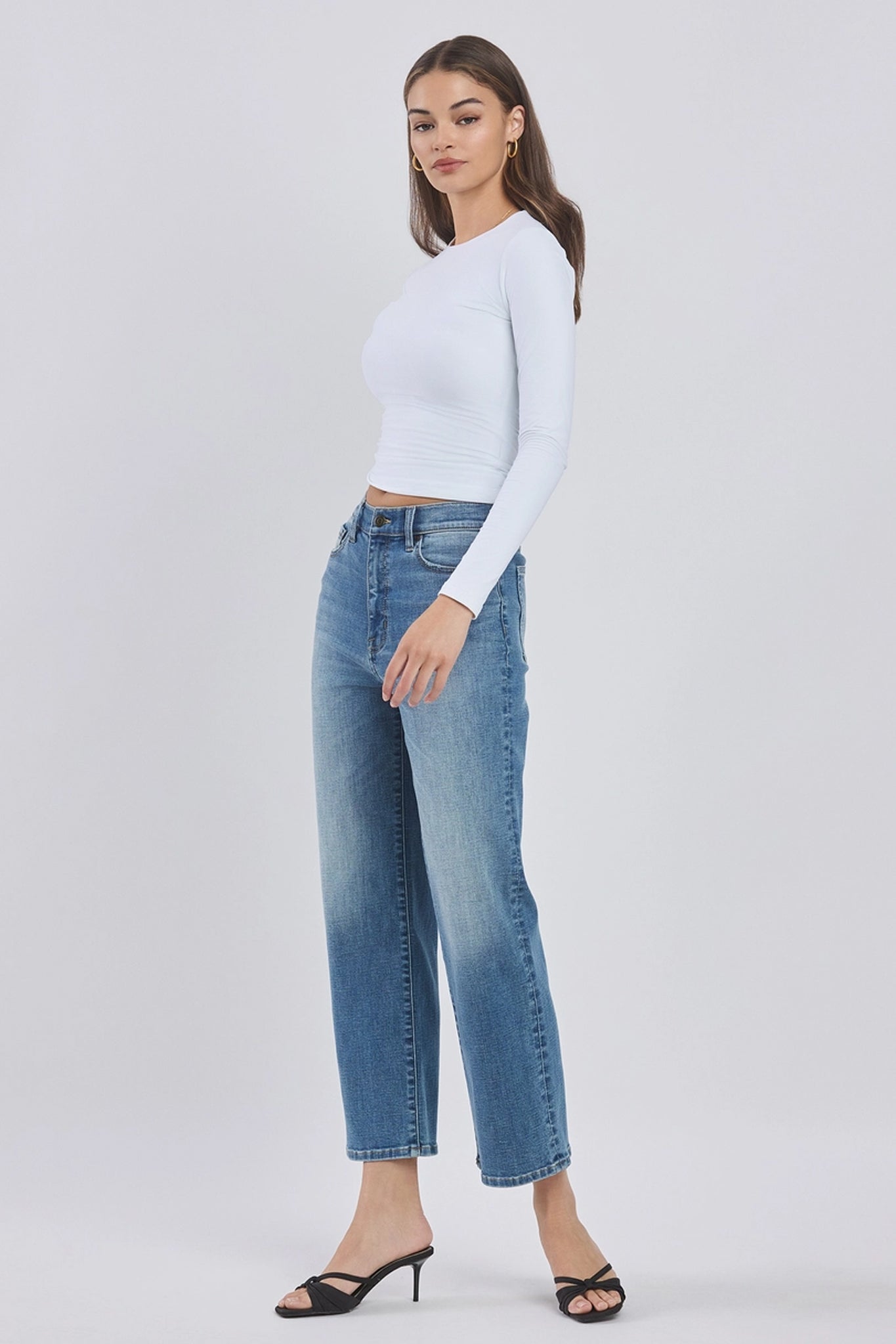 A pair of Eunina Dawn wide leg jeans in the Aliso wash, featuring a relaxed fit and a high-rise design. The jeans are styled with a pair of sunglasses, showcasing a casual and trendy look. The image emphasizes the jeans' wide leg silhouette, making them suitable for a stylish summer outfit.
