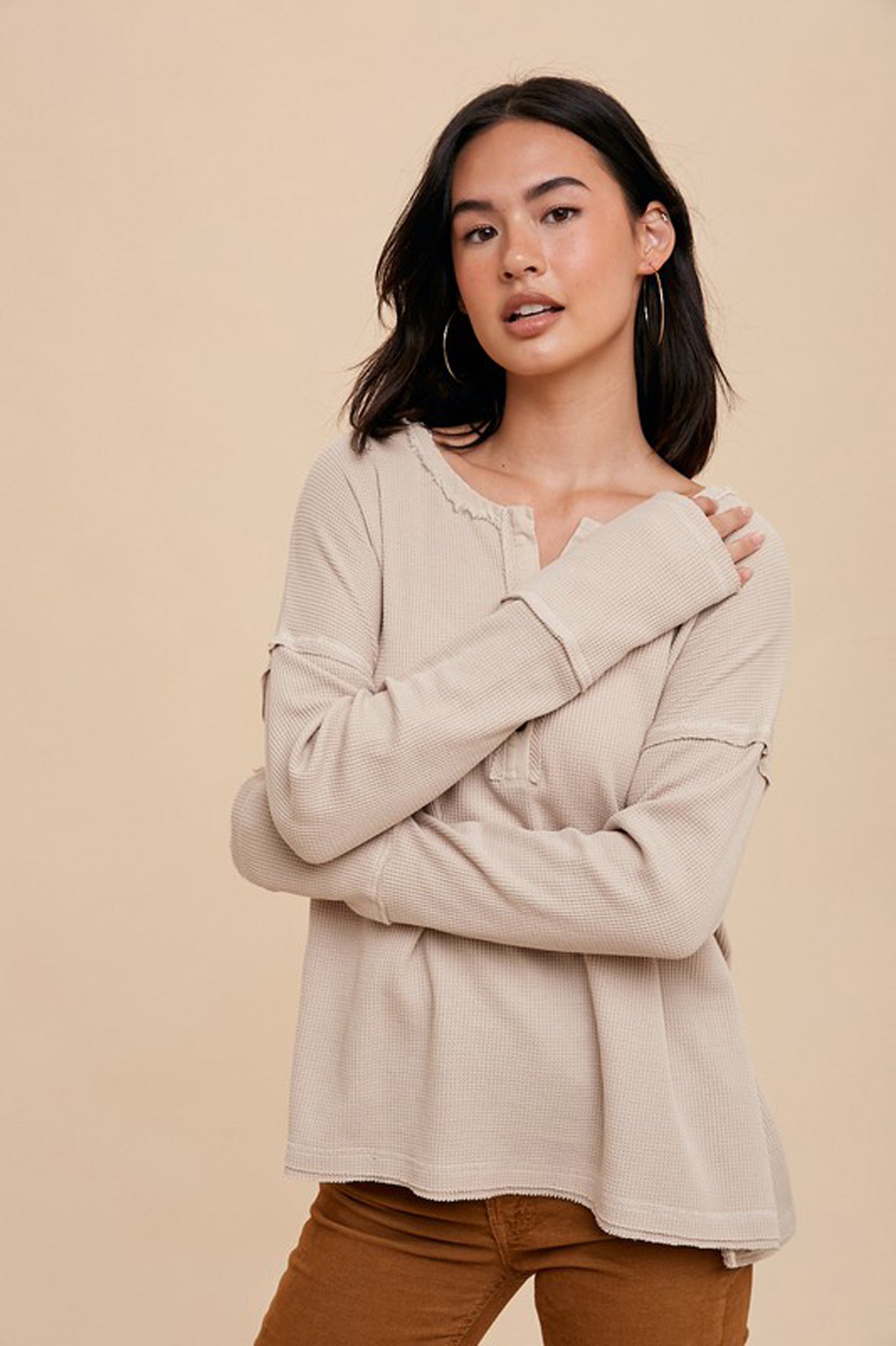 A garment washed thermal Henley top by Larrea Cove in a soft Poppi Seed color. The top features a classic Henley design with button placket and long sleeves. It is styled casually and is part of a sale collection for November 2023.