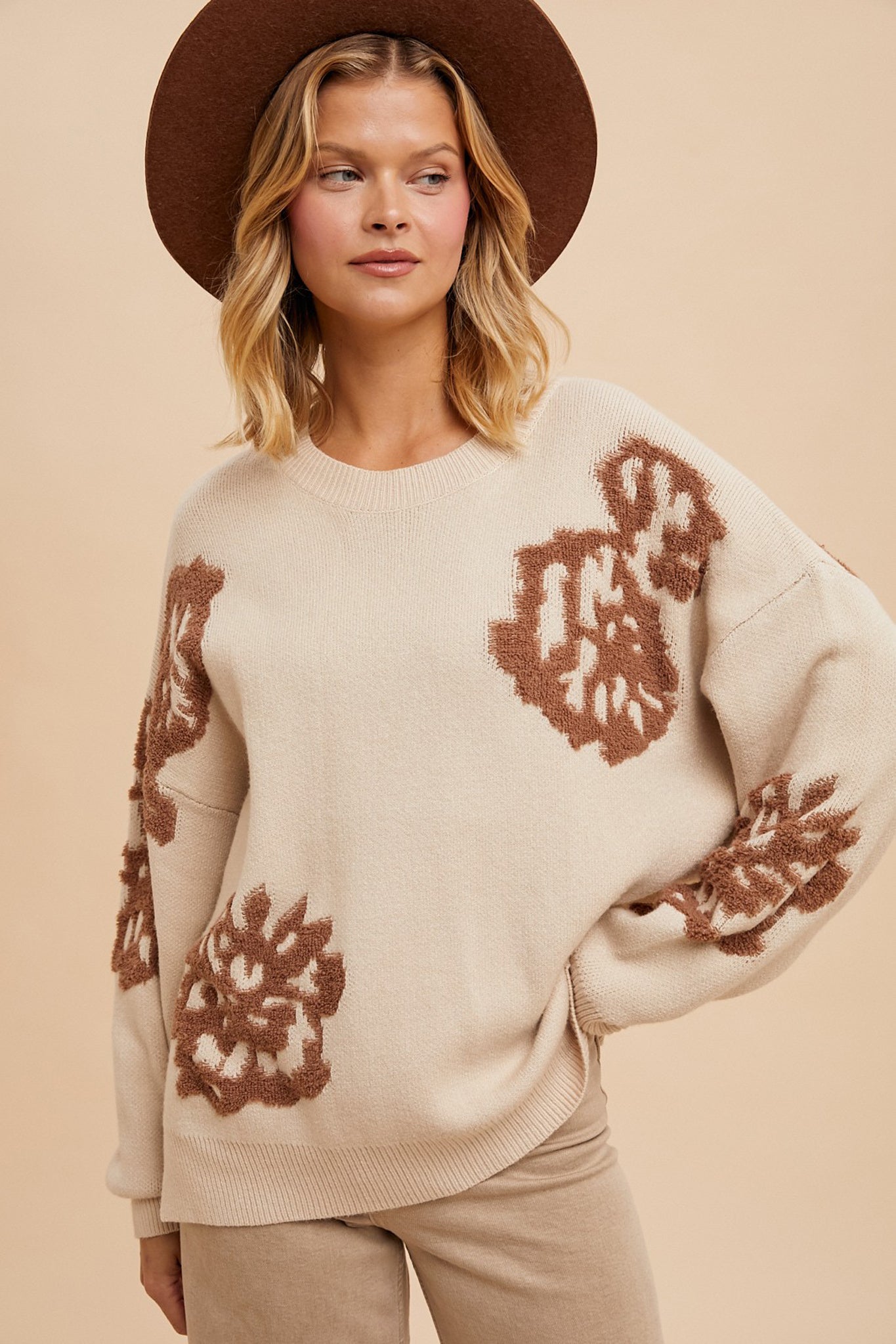 A cozy Lanta Floral Intarsia Knit Sweater by Larrea Cove, featuring a colorful floral design. The sweater is styled for Fall 2024 and is paired with trendy sunglasses. It is categorized under apparel and accessories, specifically in the sweaters section.