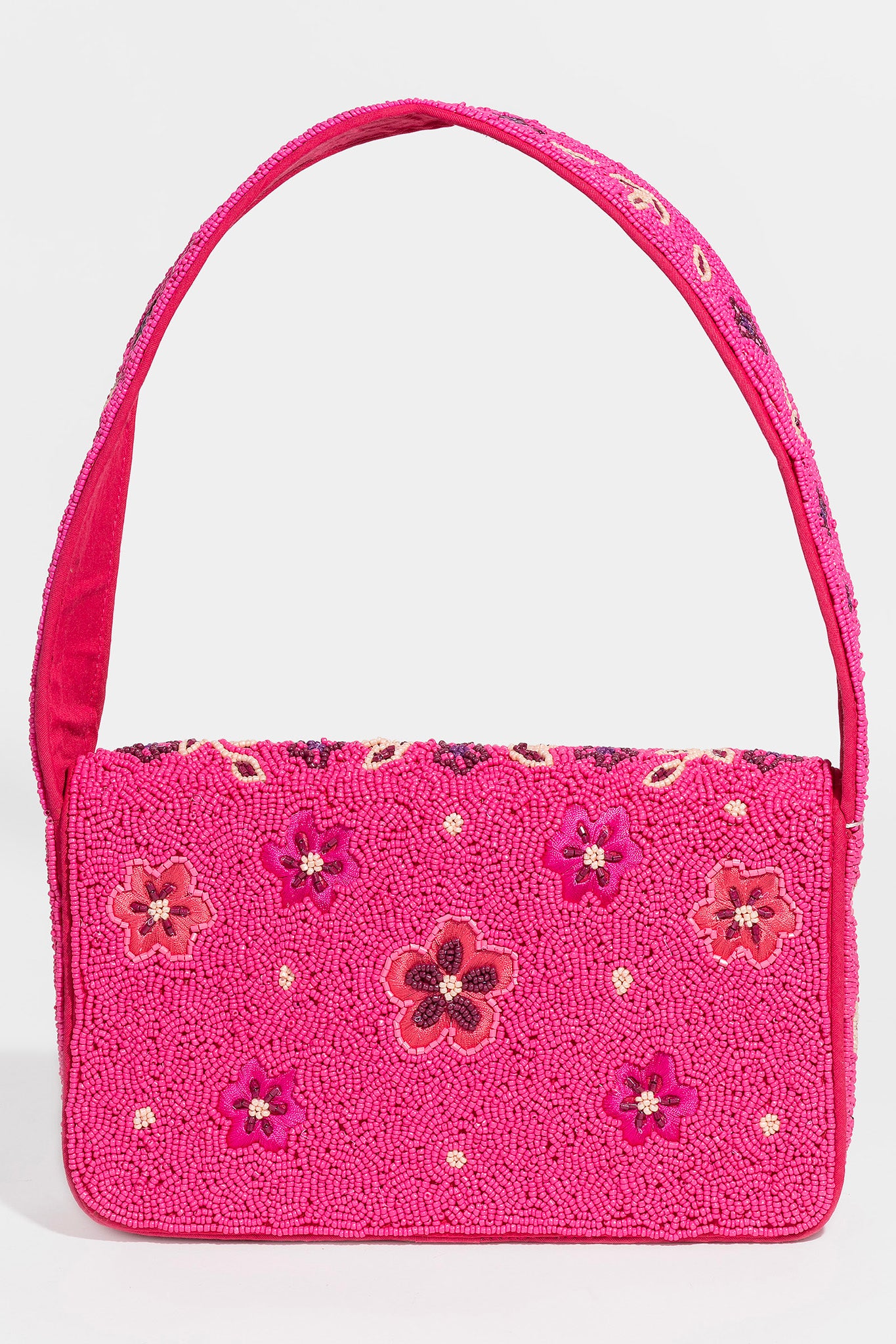 A pink hand-beaded shoulder bag by ANTIK KRAFT, featuring intricate beadwork and a stylish design. The bag is displayed alongside a pair of sunglasses, highlighting its chic and fashionable appeal. Perfect for accessory lovers looking for a unique touch in their outfit.