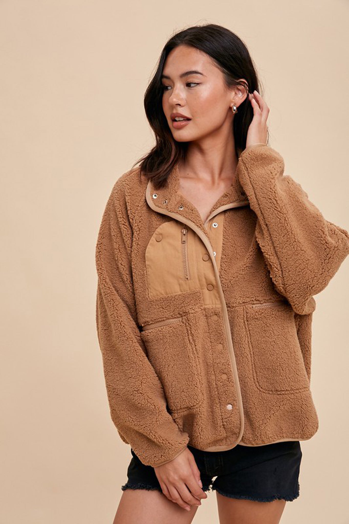 Oversized camel Sherpa jacket by Larrea Cove, featuring a cozy texture and a relaxed fit, displayed against a neutral background. Accompanied by stylish sunglasses.