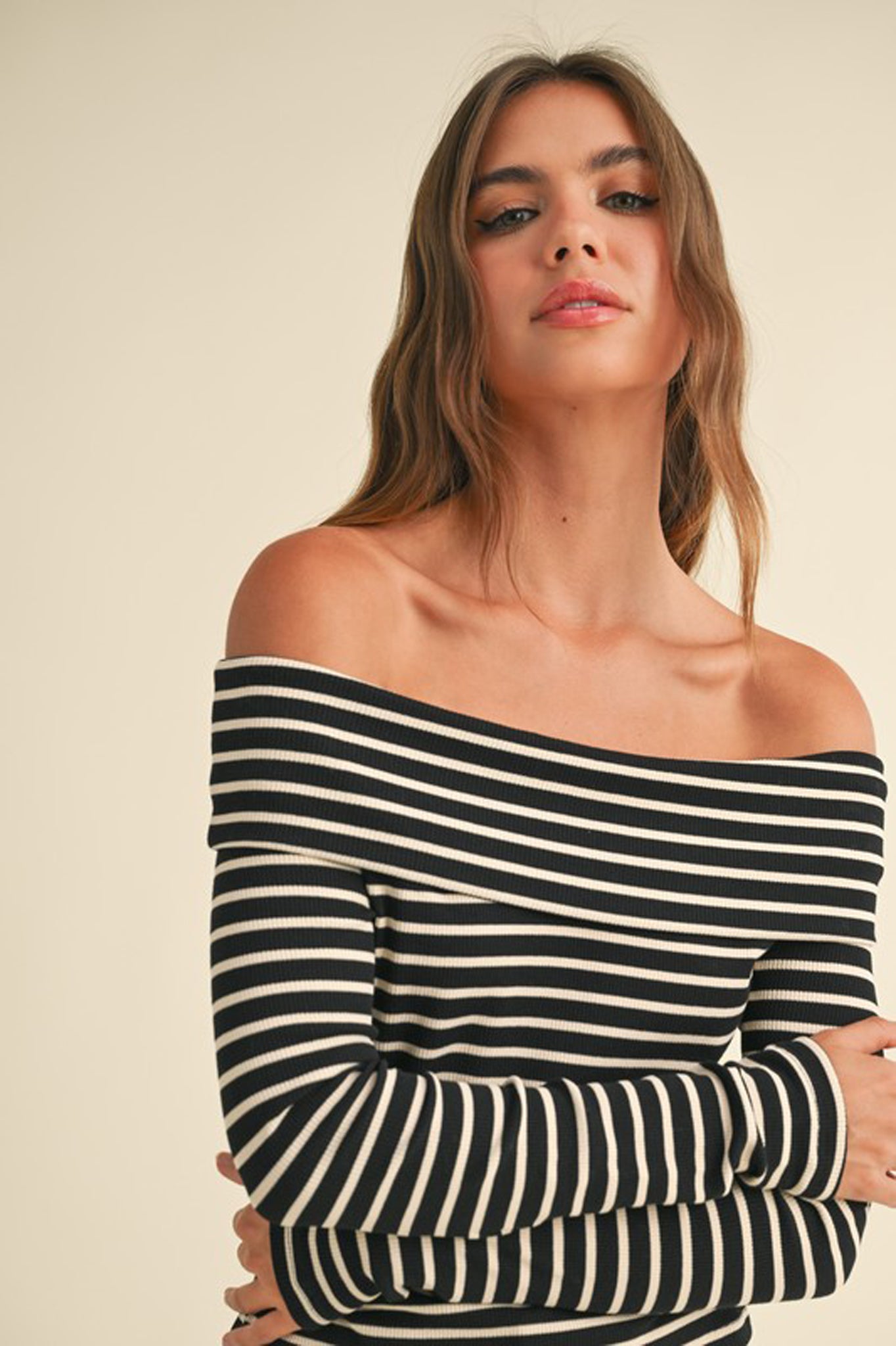 A ribbed long-sleeve off-the-shoulder top in a stylish design by Larrea Cove, suitable for fall 2024 fashion. The top is paired with trendy sunglasses, showcasing a chic and modern look.