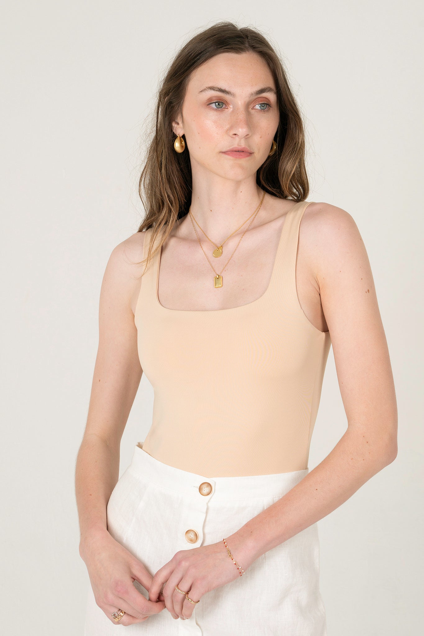 View 1 of Cara Square Neck Bodysuit in Nude, a Bodysuits from Larrea Cove. Detail: 
Achieve effortless style that’s uncomp...